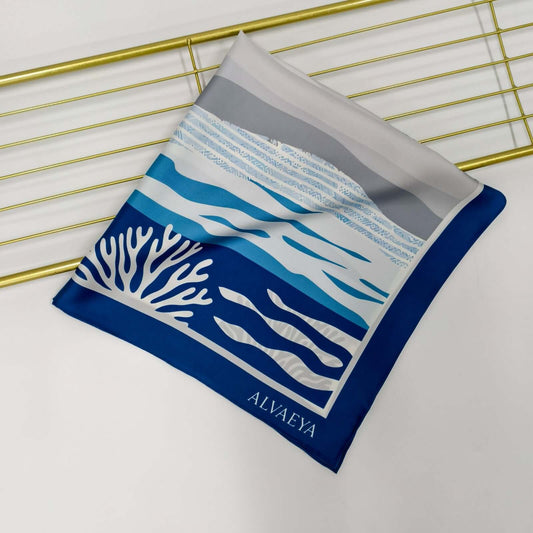 Red Sea Reef Silk Scarf from Lineage Collection featuring coral and ocean wave design in blue and gray.