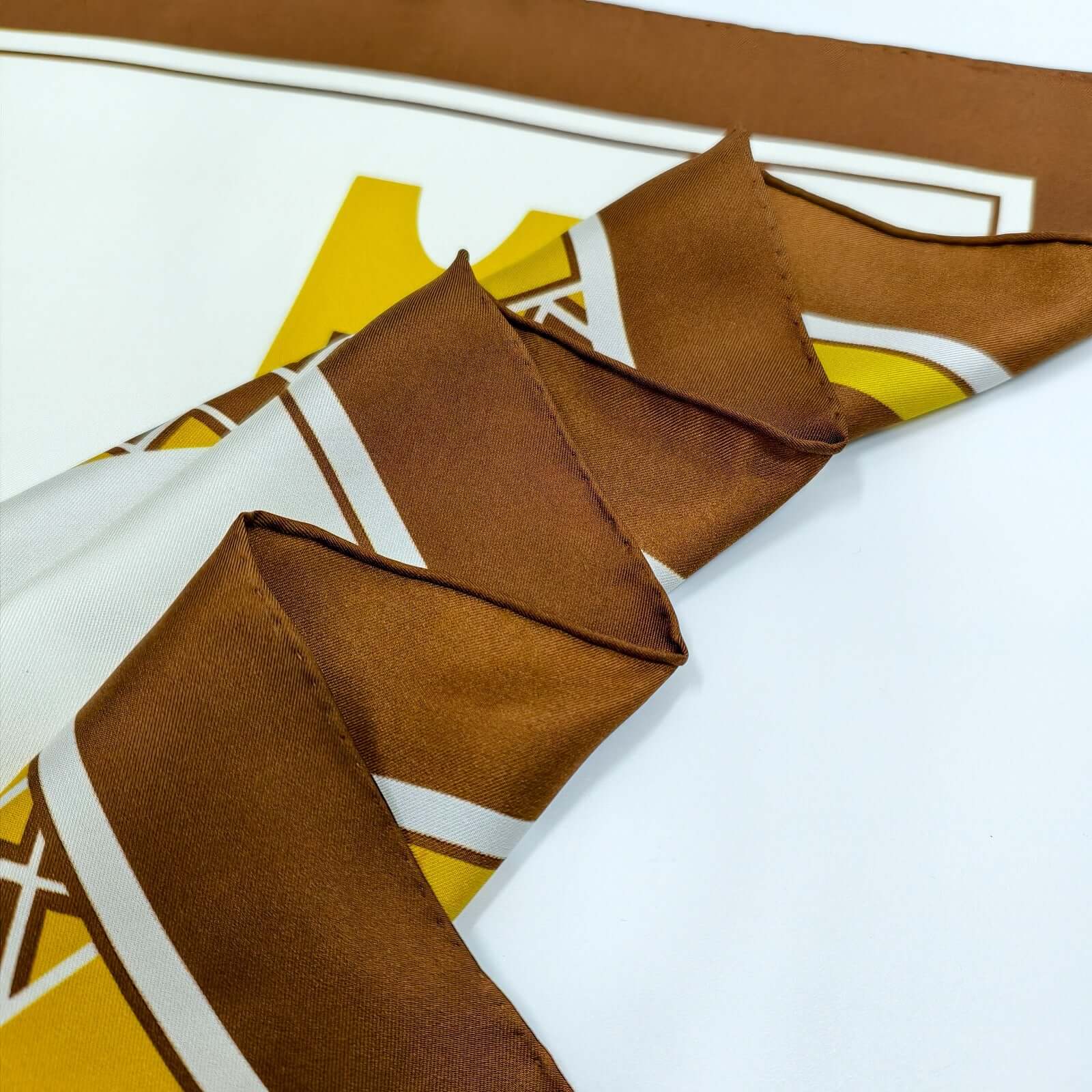 Hand Rolled Italian Edges. Najd Heritage Silk Scarf design featuring traditional architecture, camels, and palm trees in warm tones, from Alvaeya.