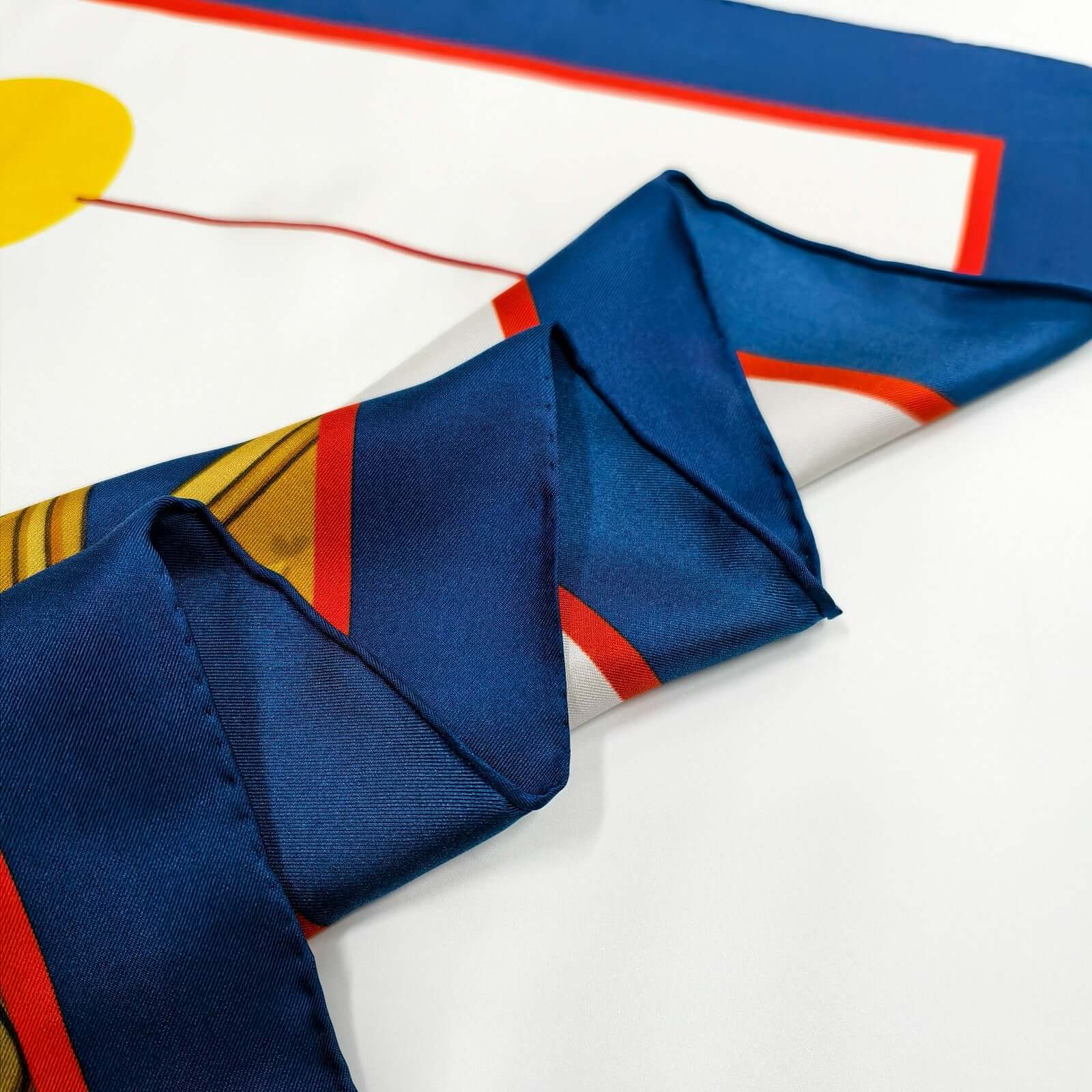 Hand Rolled Italian Edges. Ibn Batuta Silk Scarf design featuring vibrant market scenes and architectural elements from the Lineage Collection by Alvaeya.